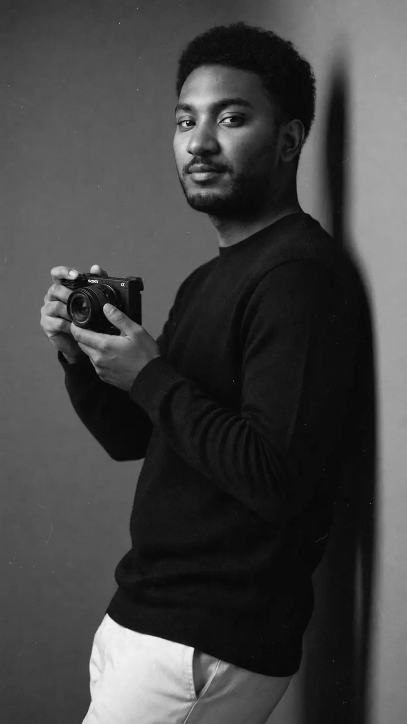 Black and white portrait of AbdEssamad Ou holding his Sony camera